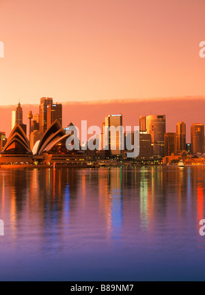 Hellen Sonnenaufgang schlagen Sydney Skyline mit Opera House was in Ruhe Wasser Sydney Harbour Stockfoto