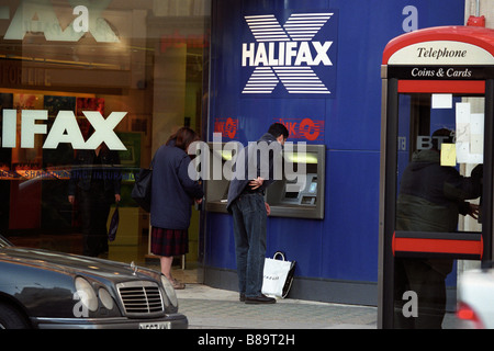 Kunden, die einen Geldautomaten in der Halifax Bank in West Kensington London Stockfoto