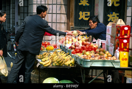 Shanghai China Street stand Man Obst kaufen Stockfoto