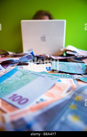 Frau hinter Laptop Computer und Euro Banknoten um. Geld im Internet zu gewinnen. Stockfoto