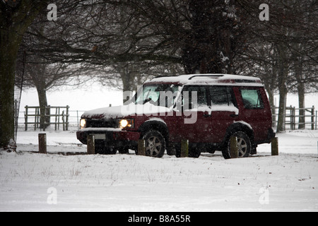 Ein 4 x 4 Landrover Discovery Fahrt durch die Schneestürme an einem kalten Wintertag Stockfoto
