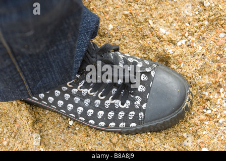 Fuß in Leinenschuhe am Strand Stockfoto