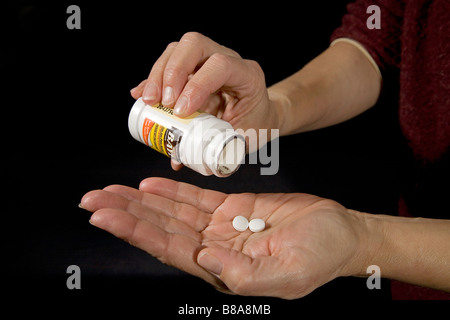 Over the Counter Medikamente wie Aspirin in Form von Tabletten, die aus der Flasche entfernt werden. Stockfoto
