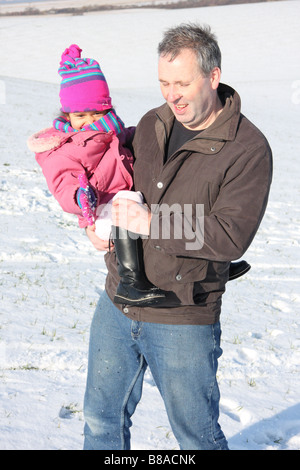 Tochter weißen Vater Tochter Toddlerl schwarzen ethnischen Mischlinge glücklich lächelnd Spaß Schnee Eis junge Stockfoto