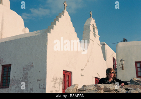 Eine Frau besucht eines der vielen malerischen Kirchen, die auf der griechischen Insel Mykonos finden Stockfoto