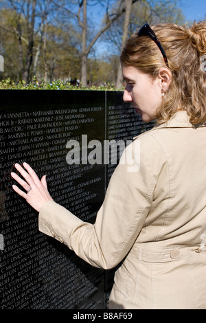 Touristischen befasst sich mit den Namen auf die Maya Lin Vietnam Veterans Memorial, Washington DC, USA Stockfoto