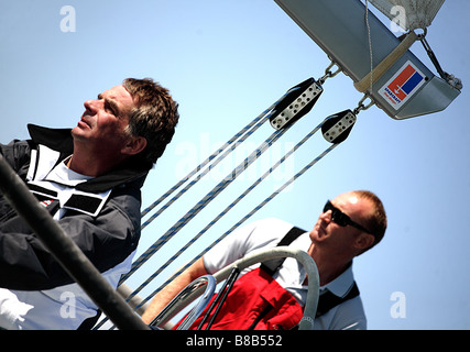 2 Männer, europäischen, weißen Segeln einer Yacht, es verfügt über Takelage und wird erschossen in einem Winkel von lw. Stockfoto