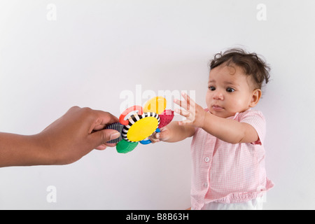 Babymädchen für ein Spielzeug zu erreichen Stockfoto