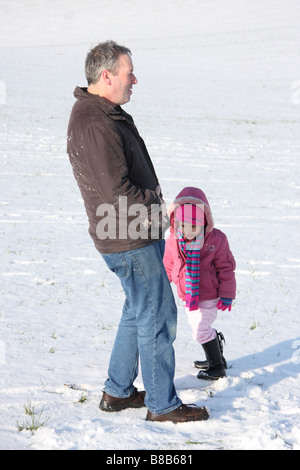 Tochter weißen Vater Tochter Toddlerl schwarzen ethnischen Mischlinge glücklich lächelnd Spaß Schnee Eis junge Stockfoto