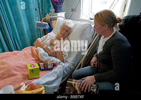 Tochter besuchen ältere Mutter Patienten im Krankenhausbett Cheltenham UK Stockfoto