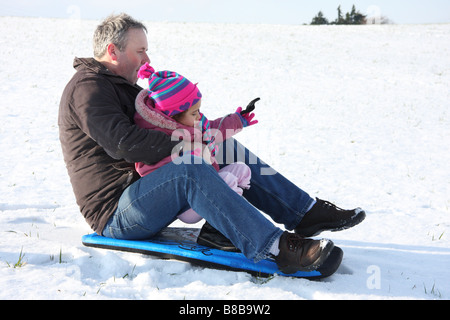 Snowboard Tochter weißen Vater Tochter Toddlerl schwarzen ethnischen Mischlinge glücklich lächelnde Spaß Schnee Eis junge Stockfoto