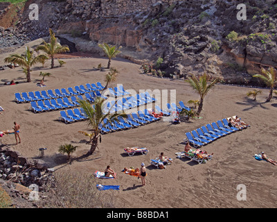 Sonnenliegen am Strand von Playa Parasio, Costa Adeje, Teneriffa, Kanarische Inseln, Spanien, Europa. Stockfoto