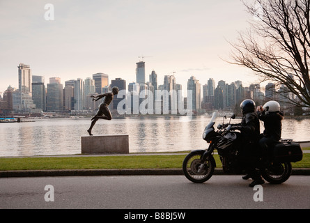 Ein paar auf einem Motorrad beobachten die Bronzestatue des kanadischen Athleten Harry Winston Jerome im Stanley Park Vancouver BC Kanada Stockfoto