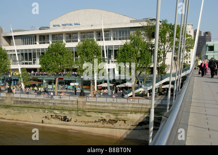 Menschen genießen die South Bank: Royal Festival Hall angesehen von Hungerford Bridge über die Themse, London Stockfoto