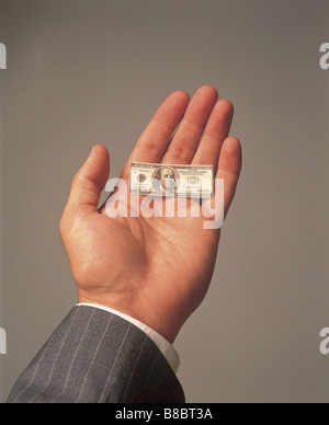 FL4572, Steve Lawrence; Unternehmenshilfe Hand mit winzigen Dollarschein Stockfoto