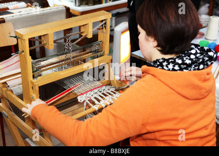 Hand-Weber arbeiten an kleinen traditionellen hölzernen Webmaschine in eine kleine Textilfabrik der Studio UK Stockfoto