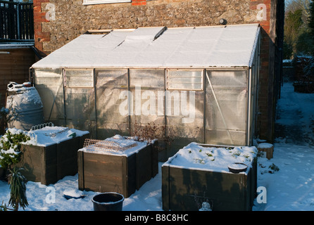 Gartengewächshaus und drei angehoben Gemüse Pflanzer im winter Stockfoto