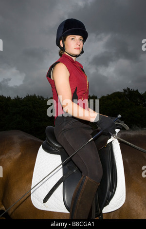 Weibliche Reiterin auf braunen Pferd sitzend Stockfoto