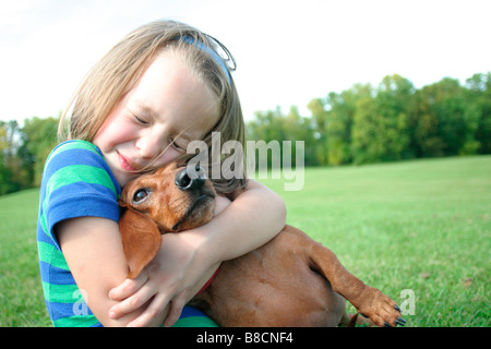 Mädchen umarmt Hund, Winnipeg, Manitoba Stockfoto