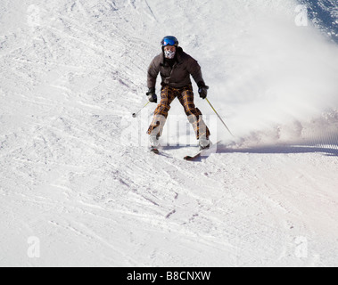 Österreich EU Januar jungen männlichen Skifahrer in einer braunen Skijacke und orange Check Hose absteigend die Pisten Stockfoto