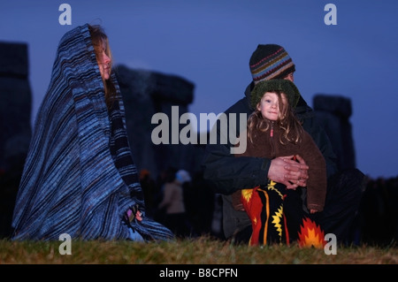 EINE FAMILIE UHR DEN SONNENAUFGANG IN STONEHENGE WÄHREND DER FEIERLICHKEITEN DER WINTERSONNENWENDE WILTSHIRE UK Stockfoto