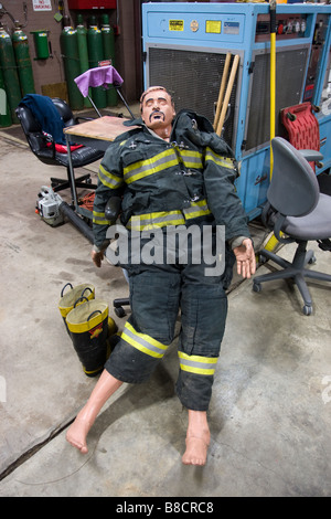 Ein Feuerwehrmann Trainingspuppe mit humorvollen Schnurrbart und Haare auf eine schützende Feuer Anzug gezeichnet Stockfoto