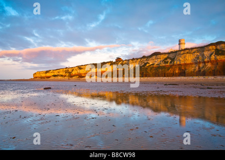 Die berühmten gestreiften Klippen am alten Hunstanton an der Küste von Norfolk mit Hunstanton Leuchtturm auf den Klippen Stockfoto