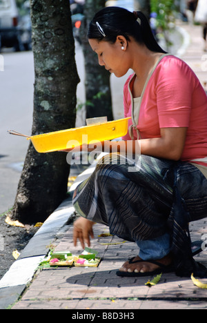 Junge Frau stellt bietet Ihnen täglich zu den Göttern am Straßenrand, Ubud, Bali, Indonesien Stockfoto