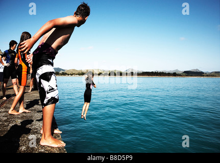 Kinder 14 Sprung von Kai ins Meer Stockfoto