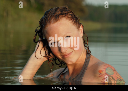 Frau mit Hand, Kopf in See, See Katherine Riding Mountain National Park, Manitoba, Kanada zu nass Stockfoto