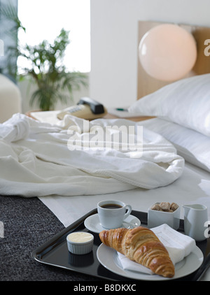 Bademantel und Frühstück auf einem Hotelbett Stockfoto