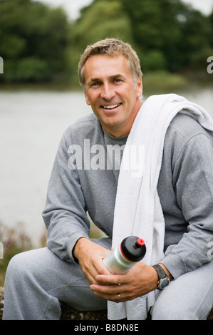 Lächelnde reifer Mann trägt einen Trainingsanzug Stockfoto