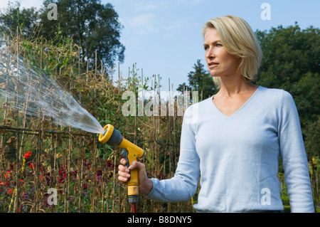Frau mit Schlauch Stockfoto