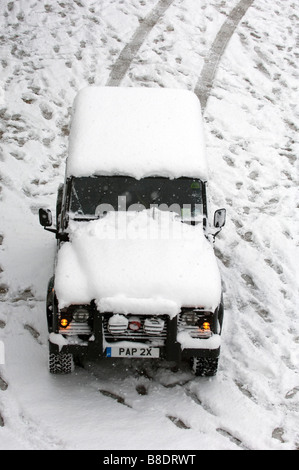 Schnee bedeckt einen Land Rover Defender 90 am Strand von Brighton East Sussex UK Stockfoto