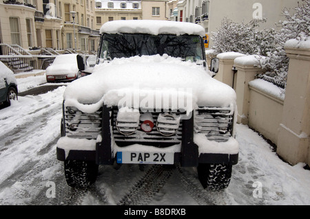 Schnee bedeckt einen Land Rover Defender 90 in Brighton East Sussex UK Stockfoto