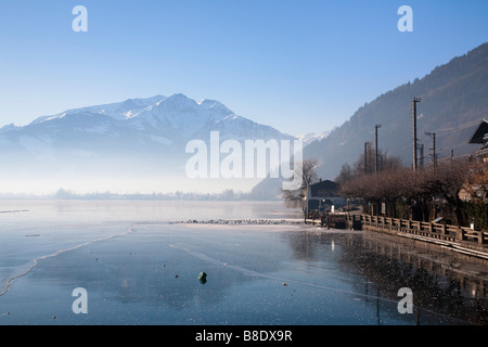 Blick über den zugefrorenen Zeller See-See mit der Luftverschmutzung im Tal im Winter. Zell am See Österreich Europa. Stockfoto