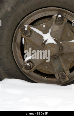 Großer LKW-Rad und Reifen-Nahaufnahme mit Schnee bedeckt. Stockfoto