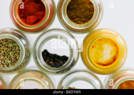 Eine Studioaufnahme des offenen Gewürzdosen übereinander, mit Pfefferkörner, Paprika, Kreuzkümmel, Kurkuma, Salbei und Kräutern ausgeglichen. Stockfoto