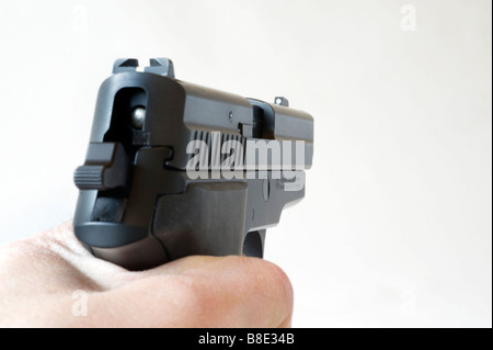 Silhouette Hand hält eine gespannte Pistole Sig Sauer 229 vor einem weißen Hintergrund Stockfoto