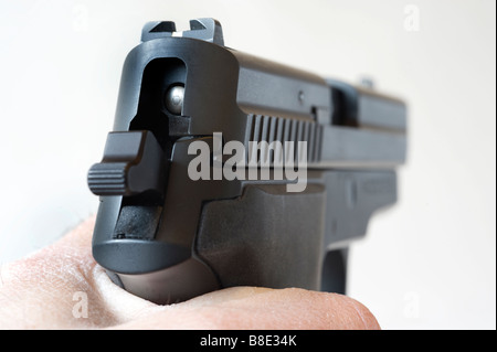 Silhouette Hand hält eine gespannte Pistole Sig Sauer 229 vor einem weißen Hintergrund Stockfoto