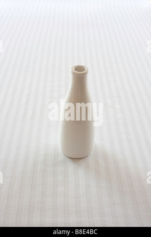 Eine weiße Vase auf einer weißen Tischdecke Stockfoto