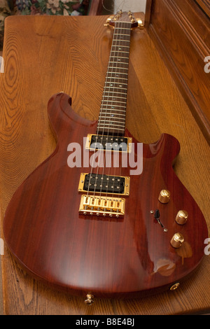 Eine benutzerdefinierte Gitarre gemacht von Padauk auf einer Butternuss-Kommode Stockfoto