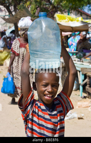 Senegalesische Boy Wassertragen auf seinem Kopf in St-Louis in Senegal Afrika