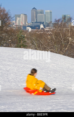 Ein junges Mädchen bergab auf einem Schlitten in Greenwich Park an einem sonnigen Tag - langsame Verschlusszeit für Motion blur. Stockfoto