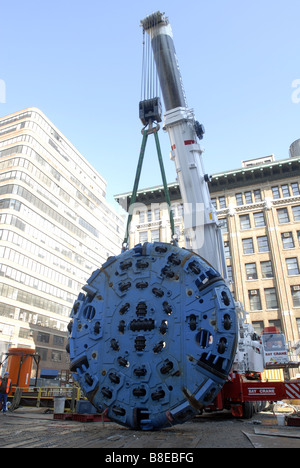 Bauarbeiter vorzubereiten, die 100-Tonnen-Schneidkopf von einer Tunnelbohrmaschine in einen Schacht in einem Plenarsaal zu senken Stockfoto