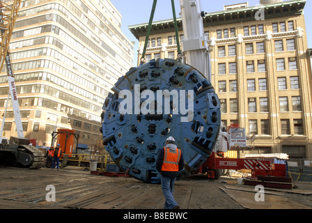 Bauarbeiter vorzubereiten, die 100-Tonnen-Schneidkopf von einer Tunnelbohrmaschine in einen Schacht in einem Plenarsaal zu senken Stockfoto