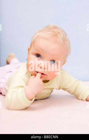 Liegenden Babymädchen 9 Monate alten indoor Stockfoto