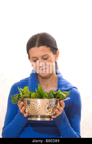 Frau mit einem Sieb Spinat Stockfoto