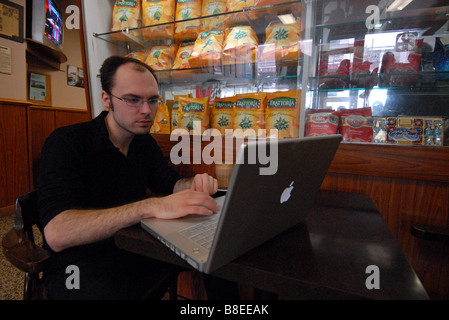 Junger Mann mit Wireless-Laptop im Café Italia Montreal Stockfoto