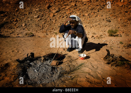 Ein Beduinen-Mann backt Brot auf einem Feuer in Ägypten Stockfoto